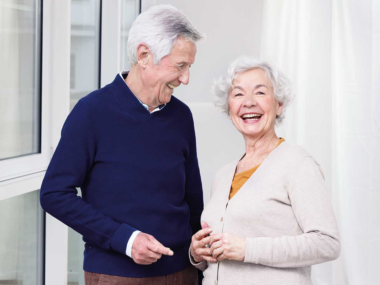 Un homme et une femme âgés souriant côte à côte